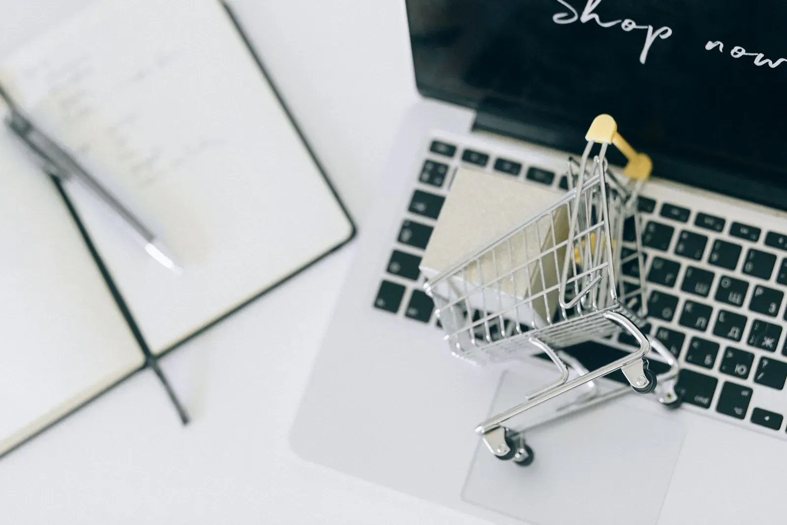 Miniature shopping cart on a laptop for ecommerce SEO