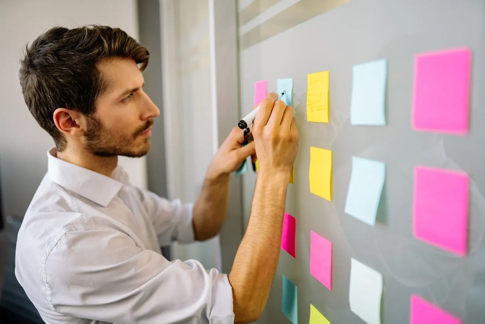 Équipe marketing qui formule des hypothèses de test A/B sur un tableau blanc avec des post-it