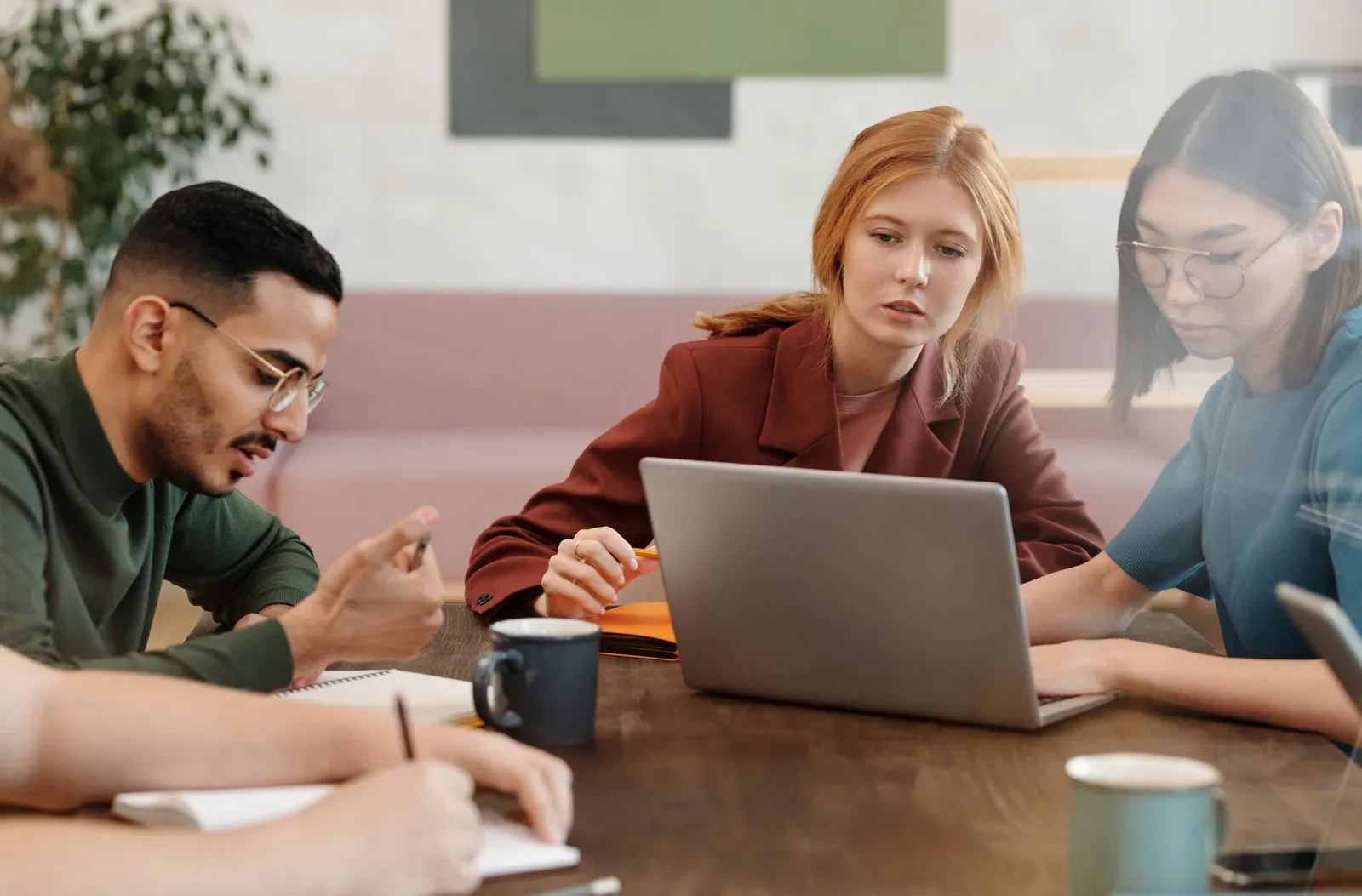 A diverse group of adults engaged in a productive team meeting in a modern office setting.